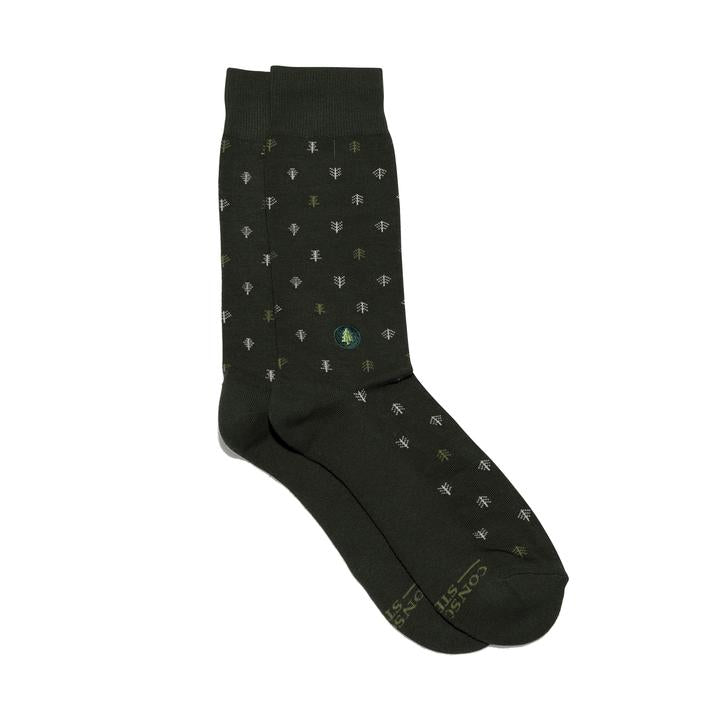 A photo of a pair of dark green socks featuring tiny trees in grey and green and a tree embroidery that help plant trees through non-profit donations with each purchase of these fair trade socks made in India.
