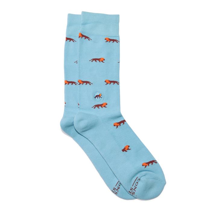 A photo of a pair of light blue crew socks with lions that help save lions through non-profit donations with each purchase of these fair trade socks made in India. 