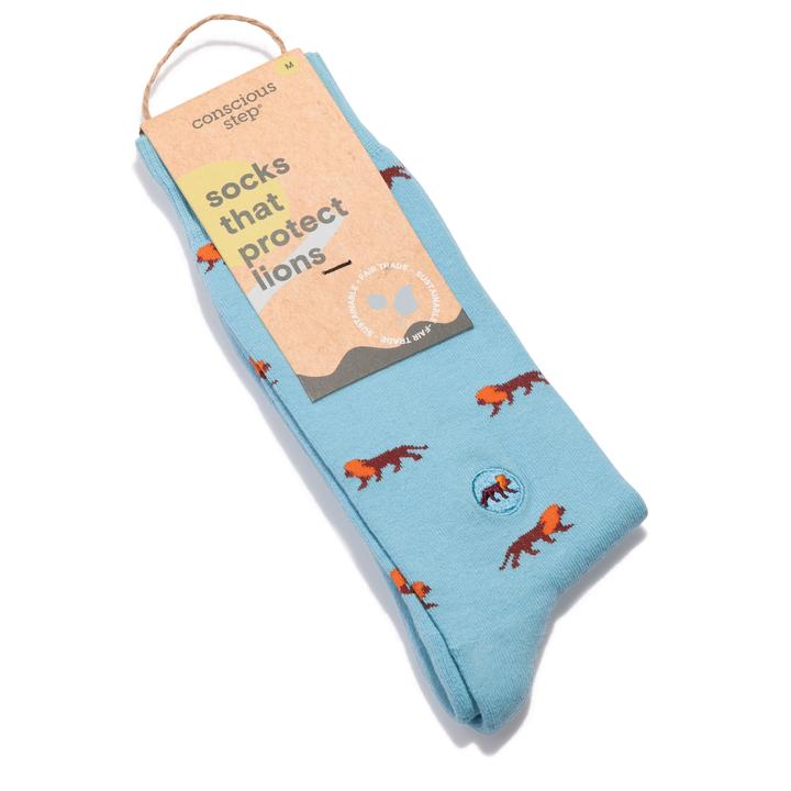 A photo of a pair of light blue crew socks with lions that help save lions through non-profit donations with each purchase of these fair trade socks made in India. 