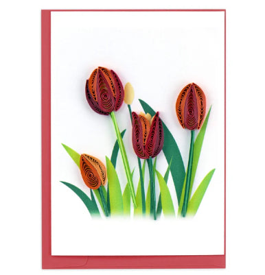 A photo of a mini greeting card made of quilling art from Vietnam. This card features red tulips growing out of grass on the front.