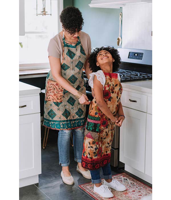 A photo of a mom and daughter wearing colorful aprons unique and handmade in Bangladesh out of Sari Material. 