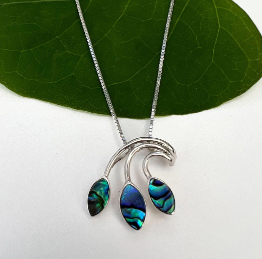 A photo of a sterling silver necklace with a leaf design made with abalone. 