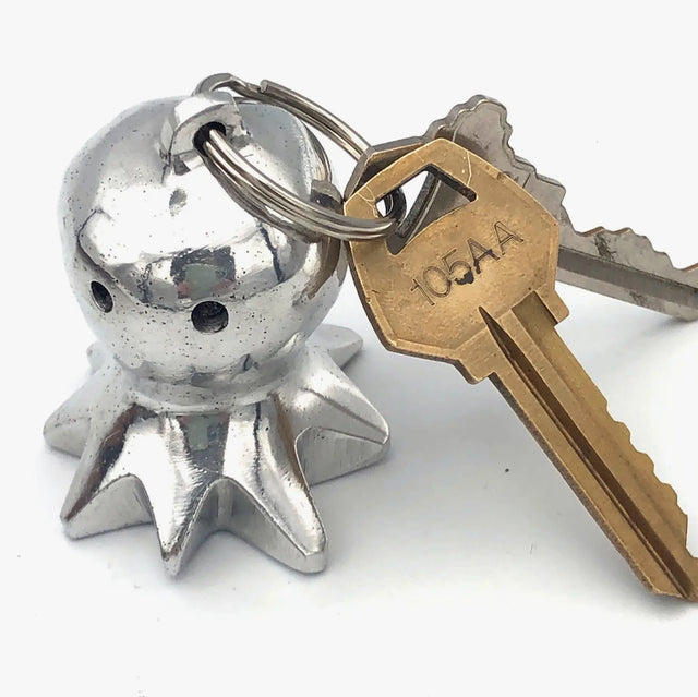A photo of a keychain made from recycled car parts in Nicaragua. This keychain is in the shape of an octopus.