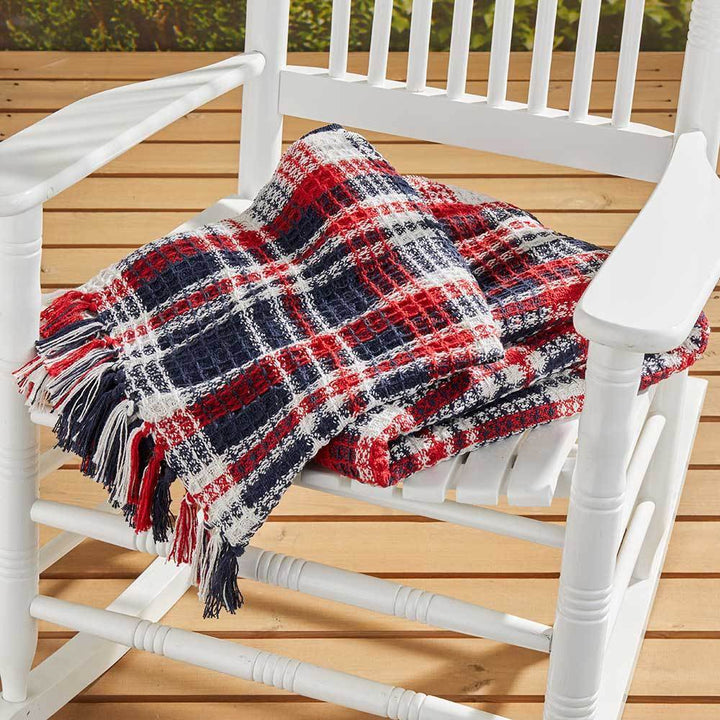 A photo of a plaid throw in Red, White, and Blue that is beautifully handcrafted in India. 