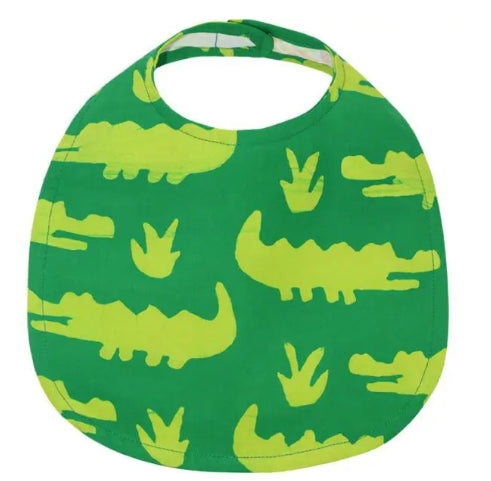 A photo of a handcrafted baby bib made from recycled flour bags in Ghana. This one features a decorative cover that is green with crocodiles.
