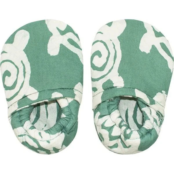 A photo of a pair of crawling shoes for babies. Made fair trade in ghana, these shoes feature a green shoe with white turtles. 