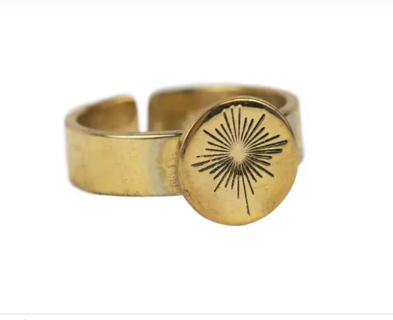 A photo of a brass ring with a guiding star design engraved into it. The brass is recycled from bombshells and landmines in Cambodia. 