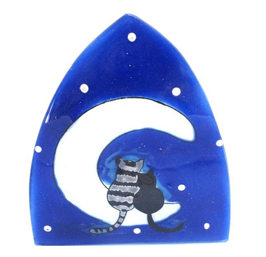 A photo of a nightlight made of recycled glass in Ecuador. This night light features a moon with 2 cats snuggles on the moon together with a blue background with stars. 