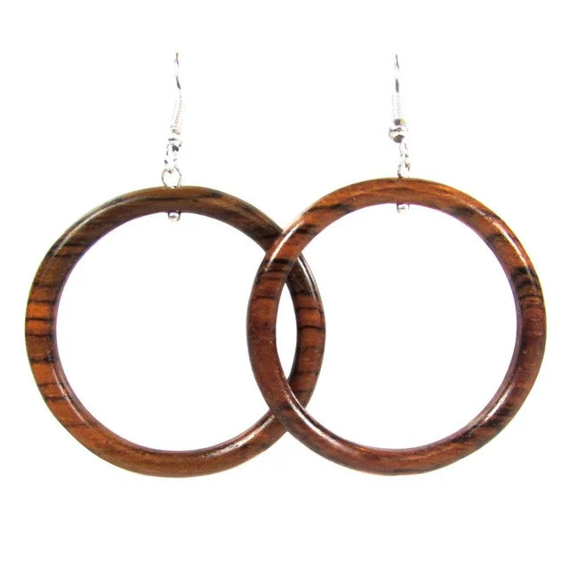 A photo of a pair of earrings that are made from reclaimed wood that are in the shape of hollow hoops. 