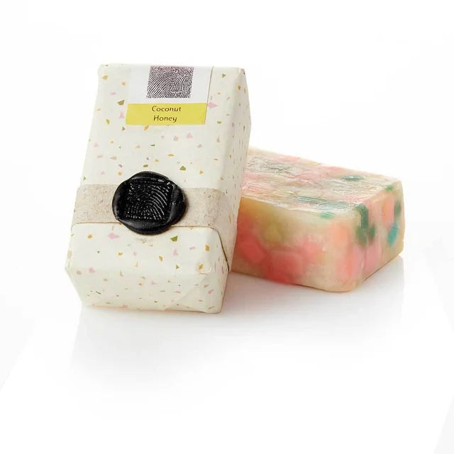 A photo of a soap bar made from Sacred Mark which is a fair trade company in Bangladesh. This soap is confetti Coconut Honey. 