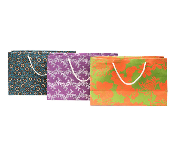 A photo of gift bags. This is the large wide size that are made of cotton recycled material. The photo shows a variety of colors and designs. 