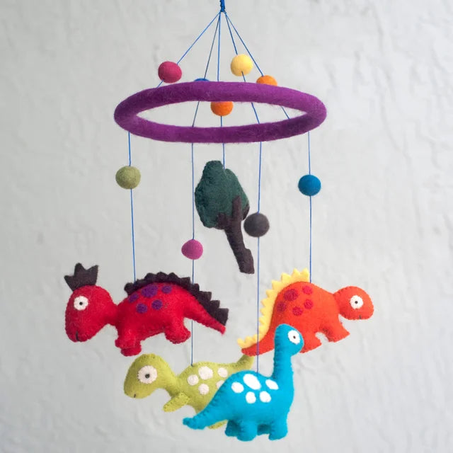 A photo of a felt mobile from Nepal. This felt mobile is made with fair trade values and is designed with colorful dinosaurs.