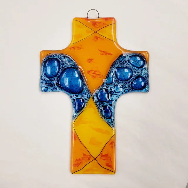 A photo of a cross made from recycled glass in Ecuador. This cross is orange and blue. 