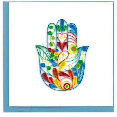 A photo of an intricately quilled greeting card made in Vietnam. This card features a Hamsa hand with lots of color and swirls and words written inside the hand; Love, Hope, Joy, Faith, and Peace