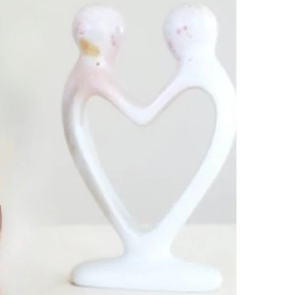 A photo of a soapstone sculpture made from kisii stone in Kenya. This one is called the heart couple, because it is natural stone made into the shape of a heart with 2 heads to symbolize a couple of people in love. 