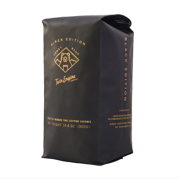 A photo of a bag of coffee. This is Twin Engine coffee made ethically in Nicaragua, grown, harvested, roasted, and packaged at the source - supporting the Nicaragua farmers. This roast is the Black Edition of 'Honey Bear'.