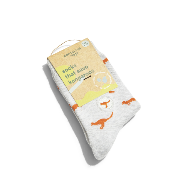 A photo of a pair of light grey kids socks with orange Kangaroos on them and the packaging that reads "Socks that Save Kangaroos".