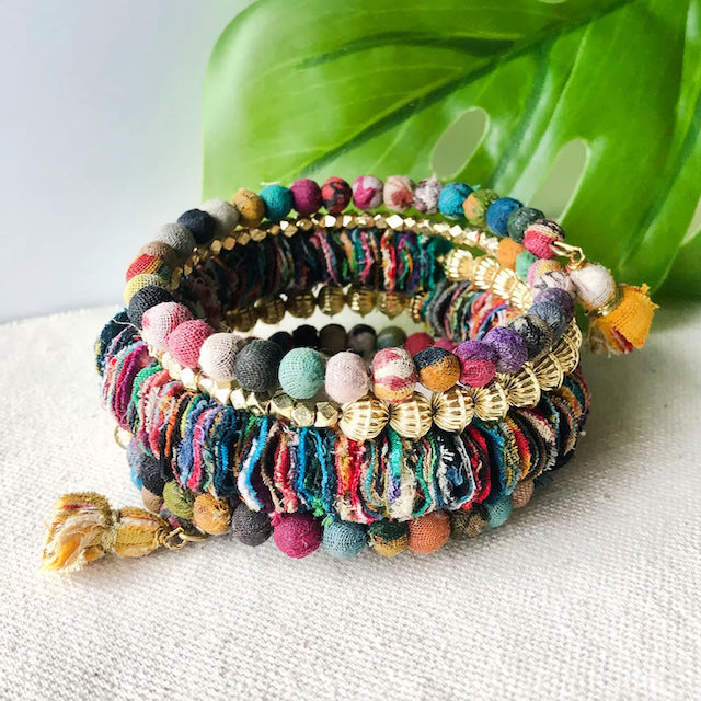 A photo of a chunky colorful wrapped bracelet made of sari material from women's clothing in India. 
