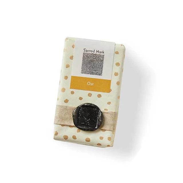 A photo of a Sacred Mark soap from Bangladesh. This bar's scent is oat.