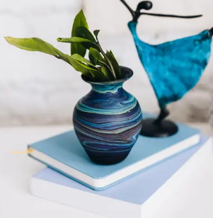 A photo of a vase with swirls of different colors of blue made in West Bank out of recycled glass. 