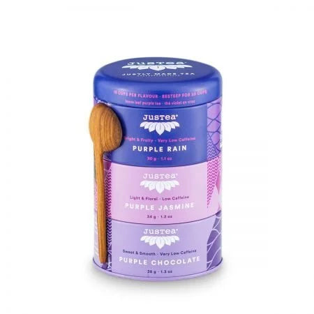 A photo of a tea trio of purple tea from Justea. The tea comes in a 3 pack canister with a wooden spoon. This is the mixed pack with Purple Rain, Purple Jasmine, and Purple Chocolate teas. 