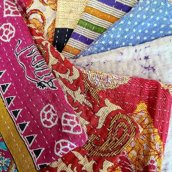 A photo of a swirl of multicolored kantha sari dish towels. 