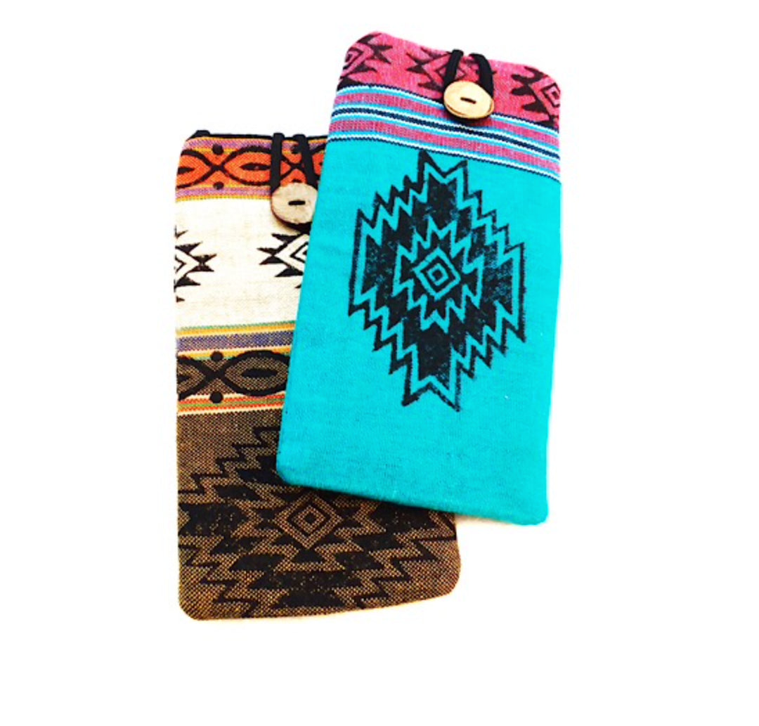 A photo of a couple of cotton eyeglass holders. These have a blockprint design in different colors. Each with a coconut button clasp with a black loop closure. 