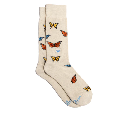 A photo of a pair of socks that give back to non-profits. These ones are beige long socks with colorful butterflies on them that help save butterflies.