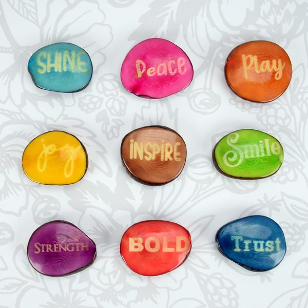 A photo of an assortment of words of wisdom on colorful Tagua nut words from Ecuador.