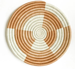 A photo of a trivet made from grass in Rwanda. This one is a tea and neutral colors in a geometric design. 