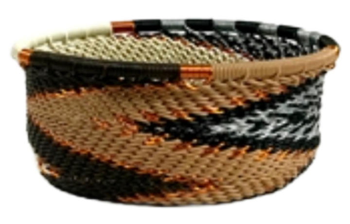 A photo of a small dish that is weaved like a basket made out of telephone wire with colors representing mocha colors; browns, blacks, reams and white with gold accents. 