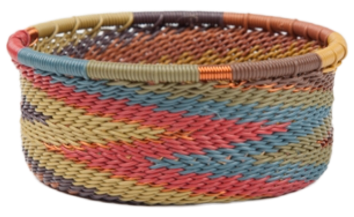 A photo of a small dish that is weaved like a basket made out of telephone wire with deep muted colors of blue, green, red, copper, and tan.