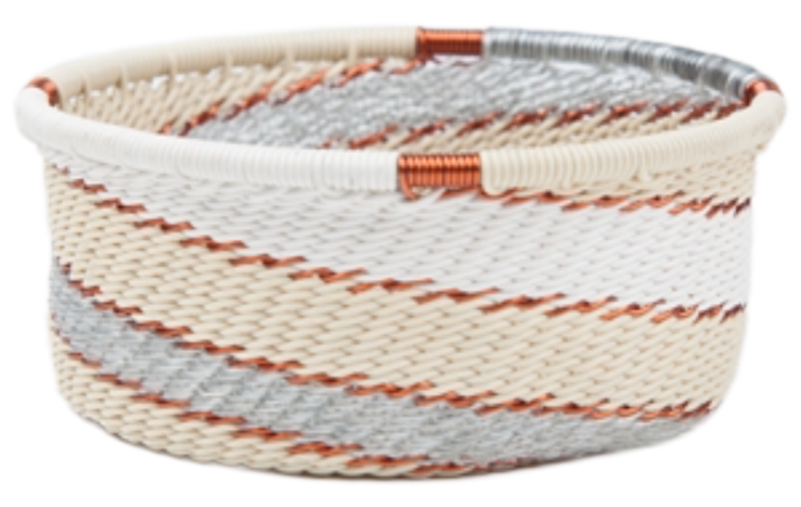 A photo of a small dish that is weaved like a basket made out of telephone wire with colors representing the silver sea, with silver, gold, grey, and cream. 