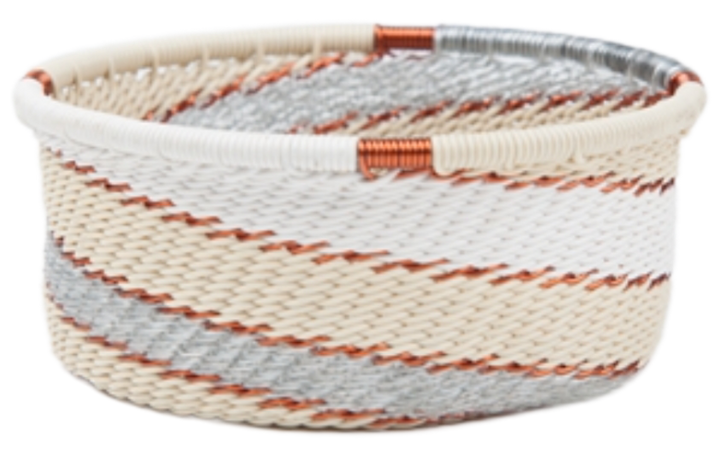 A photo of a small dish that is weaved like a basket made out of telephone wire with colors representing the silver sea, with silver, gold, grey, and cream. 