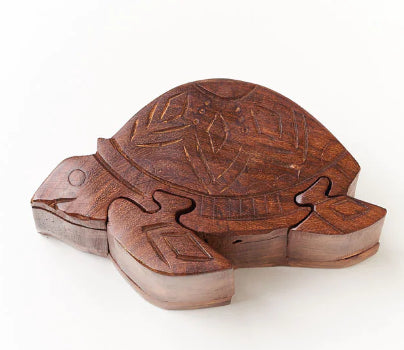 A photo of a turtle that is actually a puzzle box made of mango wood from India. 