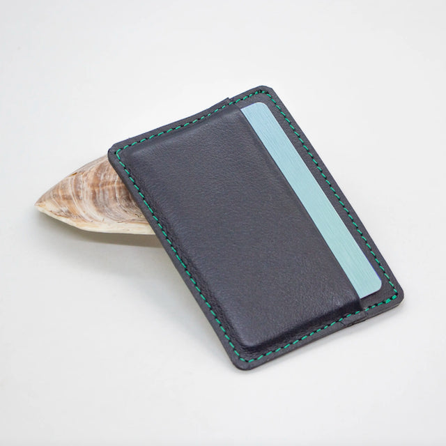 A photo of a navy blue minimalist wallet made of ethical leather in Nicaragua. 